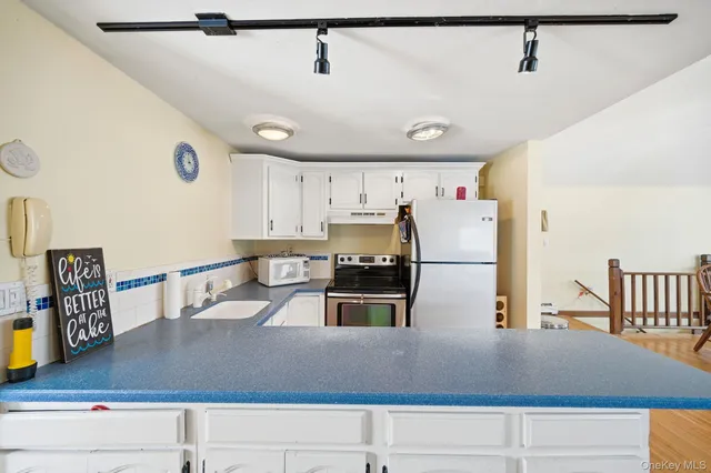 a kitchen with kitchen island a counter top space a sink and appliances