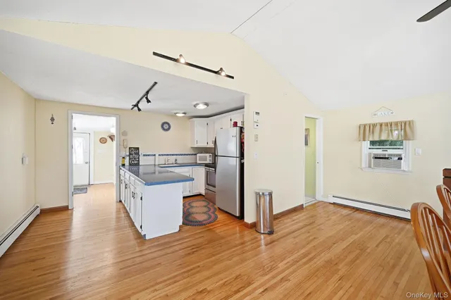 a kitchen with a refrigerator and a wooden floor