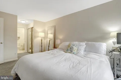 a large bed sitting in a bedroom and a lamp