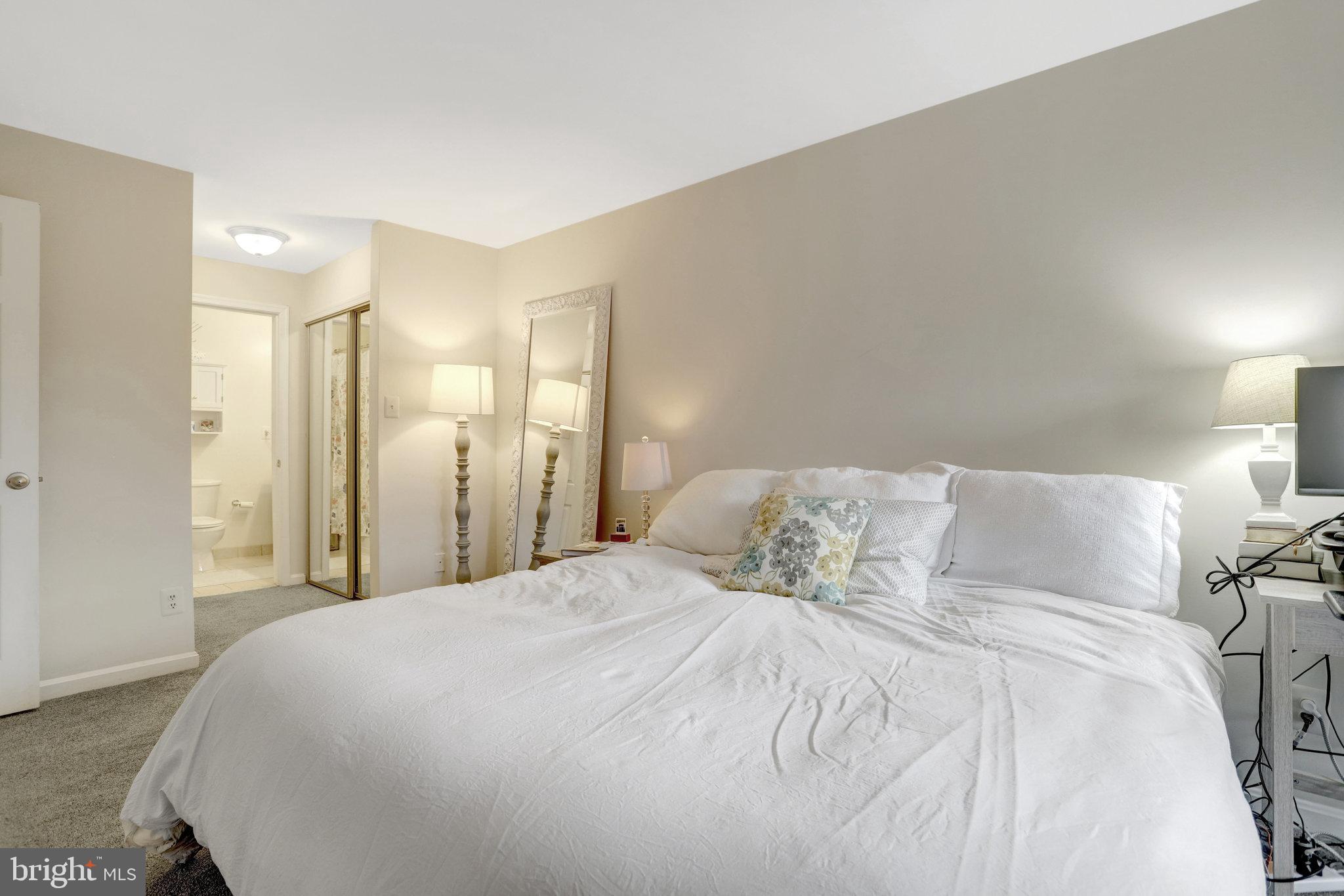 2101 North Rolfe Street, Unit C Arlington, VA 22209 - Photo 21 of 26 a large bed sitting in a bedroom and a lamp