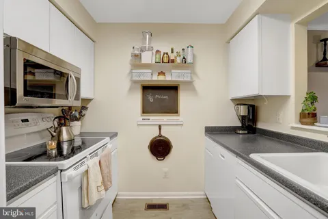 a kitchen with a sink a microwave and cabinets