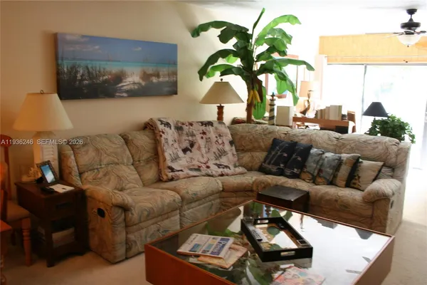 a living room with furniture and a potted plant