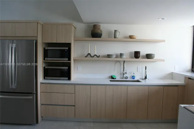 a kitchen with white cabinets and refrigerator