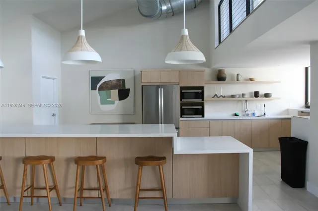 a kitchen with stainless steel appliances kitchen island a table and chairs in it