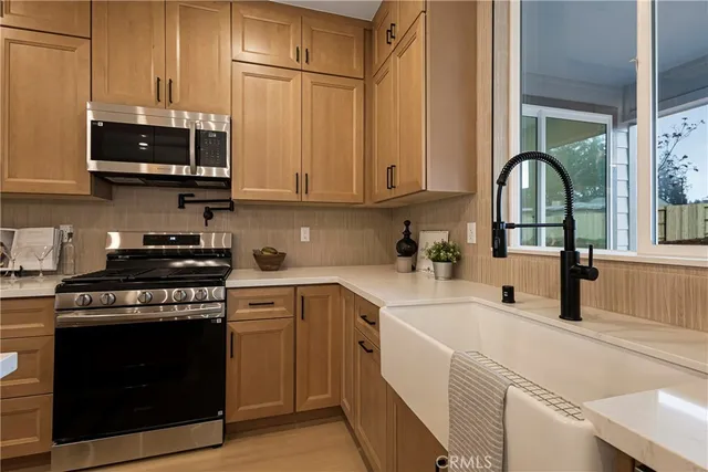 a kitchen with stainless steel appliances granite countertop a stove a sink and a microwave