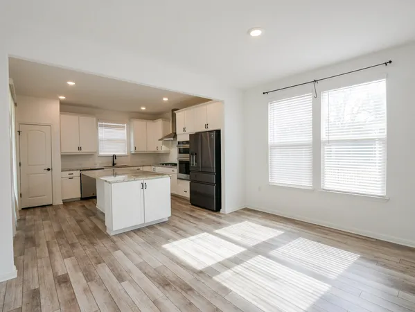 a large kitchen with a window and stainless steel appliances