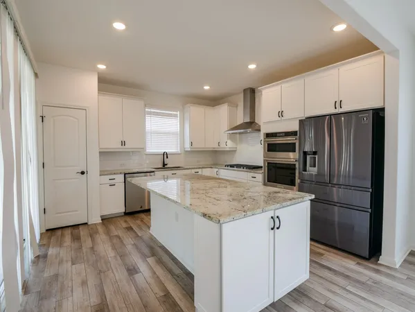 a kitchen with a refrigerator a sink and cabinets