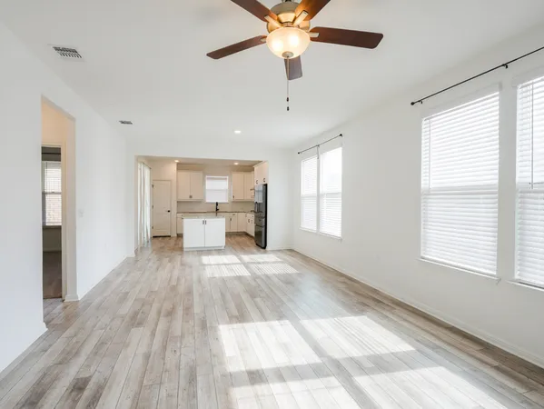 a view of a living room a window and a chandelier fan