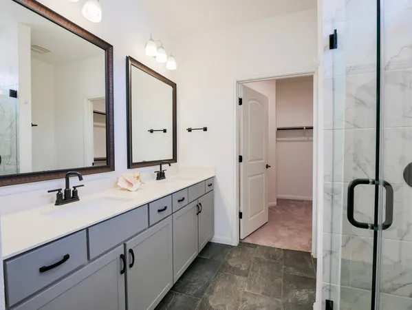 a bathroom with a double vanity sink mirror and shower