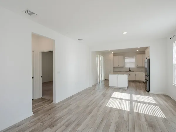a living room with a couch and a view of kitchen