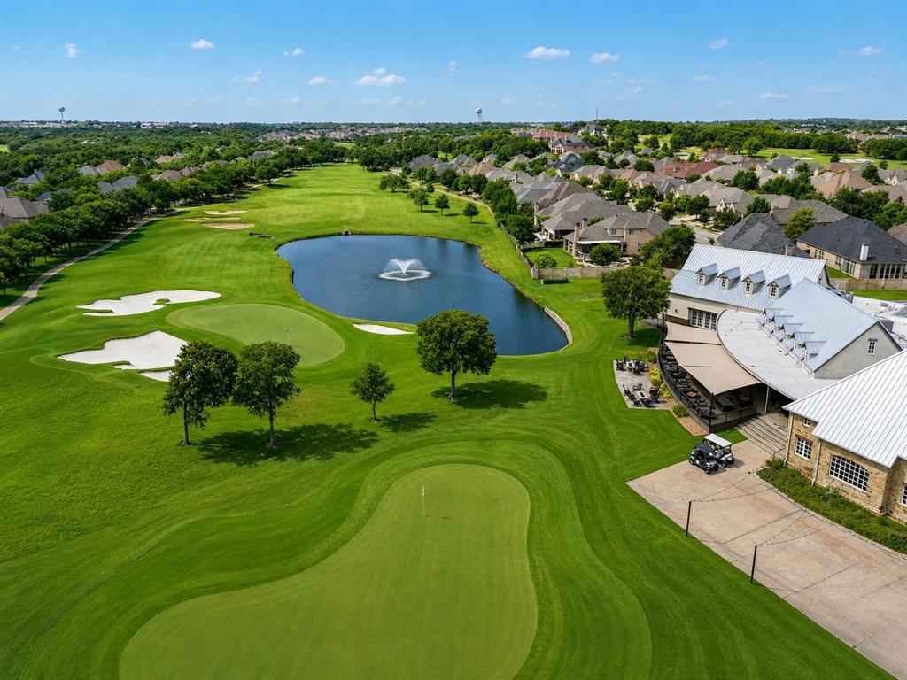 920 Sheldon Road Argyle, TX 76226 - Photo 31 of 36 Expansive championship-caliber golf course featuring manicured fairways with strategic bunkering, a pristine water feature with fountain centerpiece, mature specimen trees throughout, and a clubhouse with distinctive architectural detailing visible at the property's edge