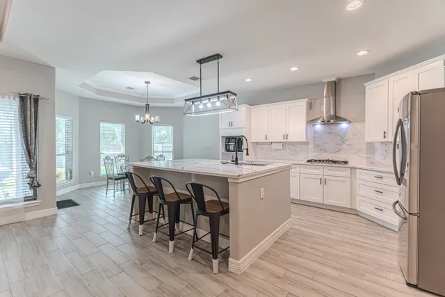 a kitchen with stainless steel appliances a dining table chairs stove and refrigerator