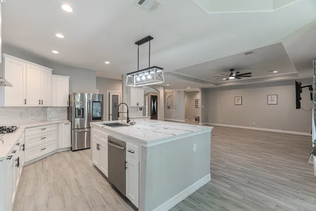 a open kitchen with stainless steel appliances granite countertop a sink stove and refrigerator