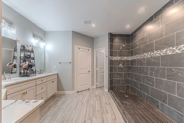 a bathroom with a sink mirror and a shower