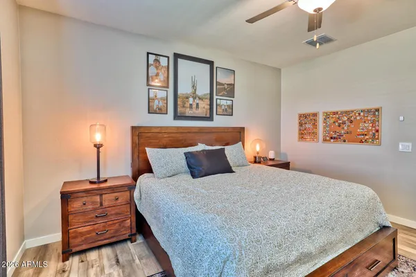 a bedroom with a bed and a lamp on dresser
