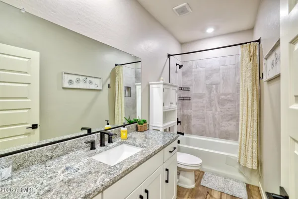 a bathroom with a granite countertop tub sink toilet and shower