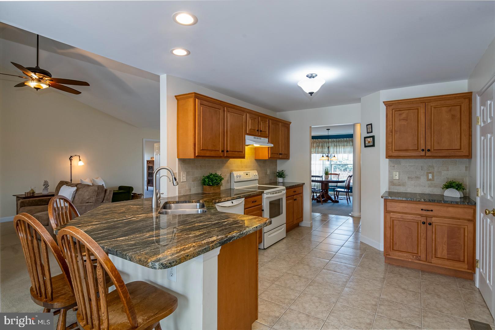 382 Tilden Road Mohrsville, PA 19541 - Photo 15 of 34 a kitchen with kitchen island granite countertop wooden cabinets a stove a sink a dining table and chairs