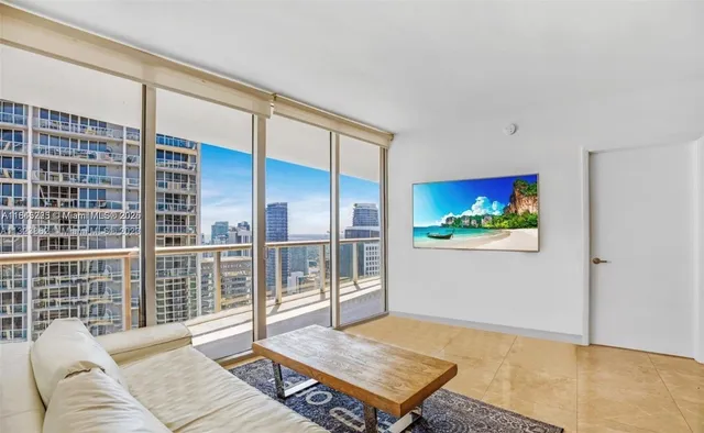 a living room with furniture a rug and a floor to ceiling window