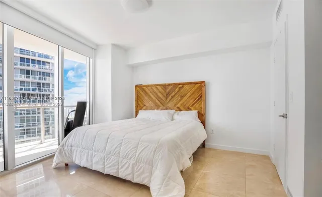 a bedroom with a bed and a large window