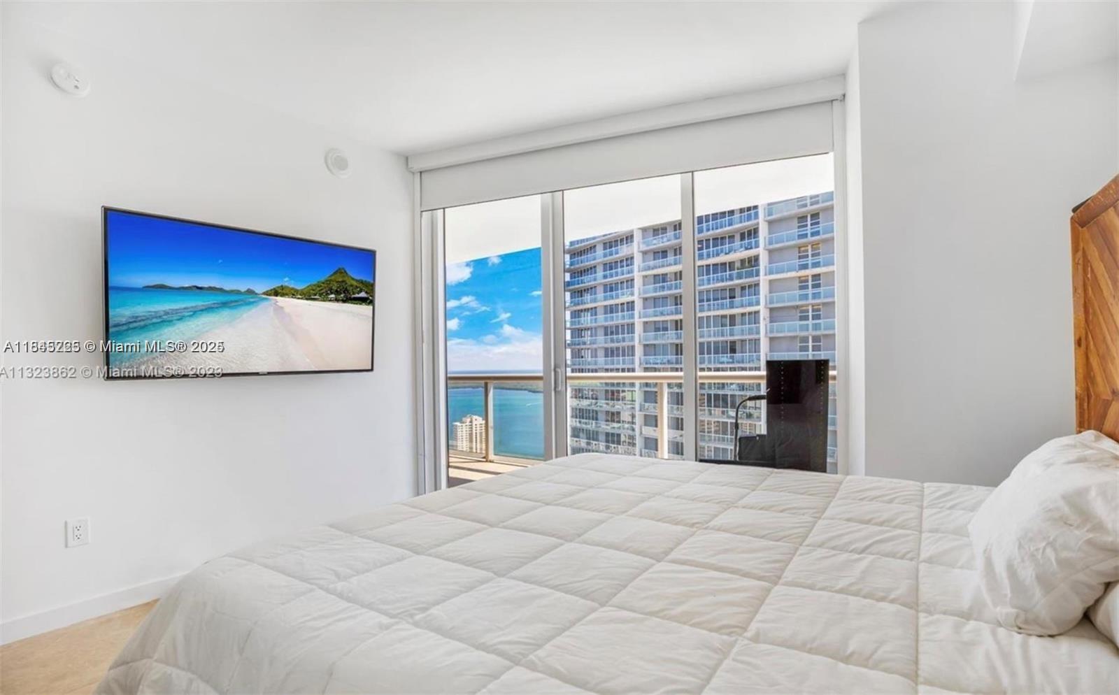 475 Brickell Avenue, Unit 4909 Miami, FL 33131 - Photo 7 of 9 a bedroom with a bed and a large window