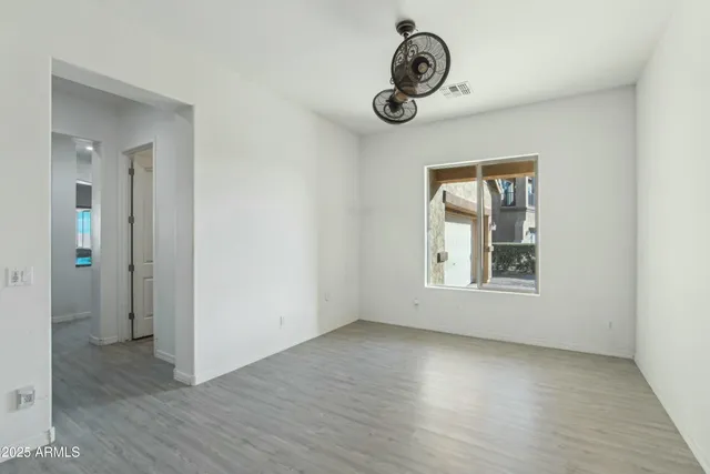 a view of an empty room with window and stairs