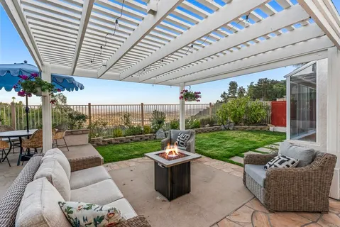 a view of a patio with couches table and chairs and a big yard