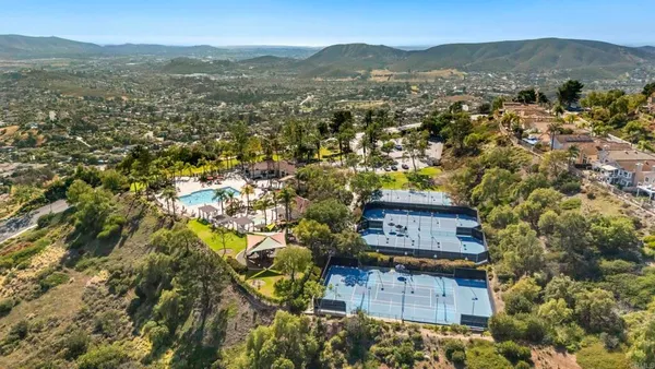 an aerial view of a house with a mountain