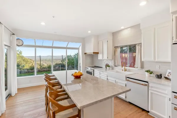 a kitchen with a sink a counter top space and living room filled with furniture