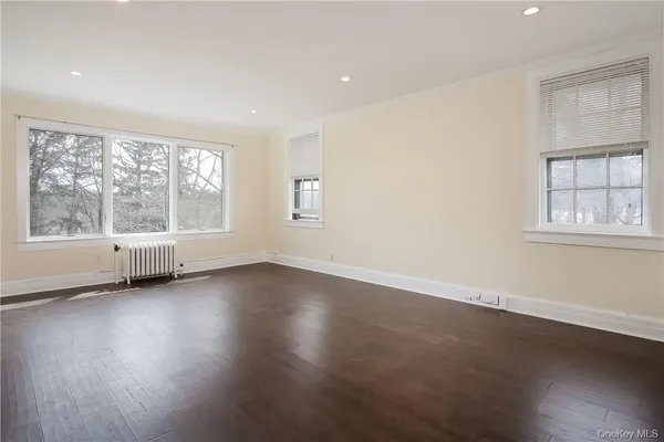a bedroom with a large bed and a flat tv screen on dresser