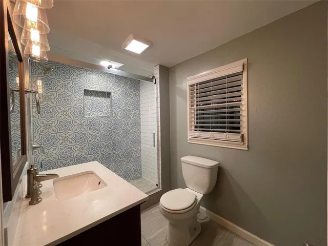 a bathroom with a sink toilet and shower