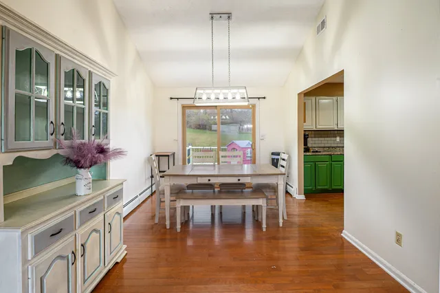 a dining room with furniture window and wooden floor