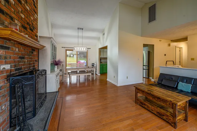 a living room with furniture a dining table and chairs with wooden floor
