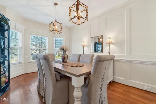 a kitchen with stainless steel appliances granite countertop a table chairs refrigerator and microwave