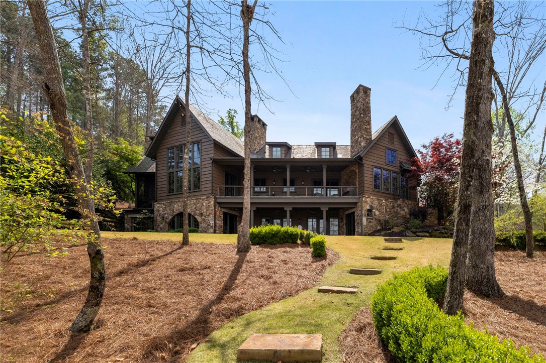 195 Village View Drive Sunset, SC 29685 - Photo 6 of 48 This exquisite property showcases a captivating exterior with rich wood and stone finishes, nestled amidst lush greenery.