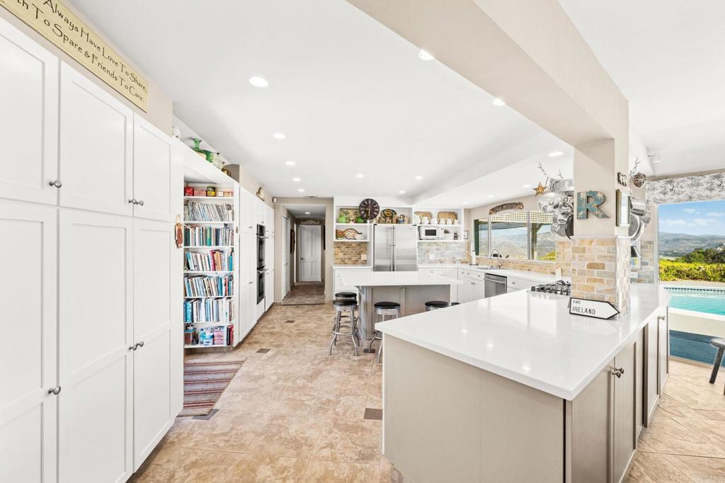 3730 Poppy Lane Fallbrook, CA 92028 - Photo 22 of 75 a kitchen with stainless steel appliances kitchen island granite countertop a table and chairs
