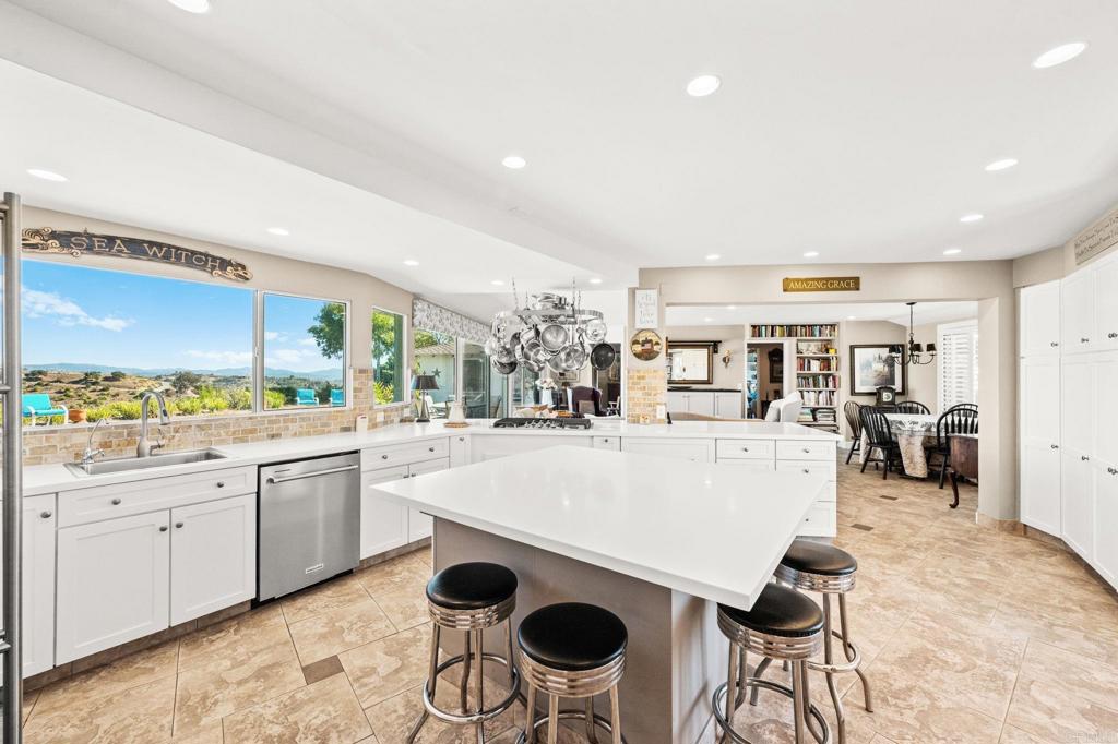 3730 Poppy Lane Fallbrook, CA 92028 - Photo 25 of 75 a large kitchen with kitchen island a stove a table and chairs in it
