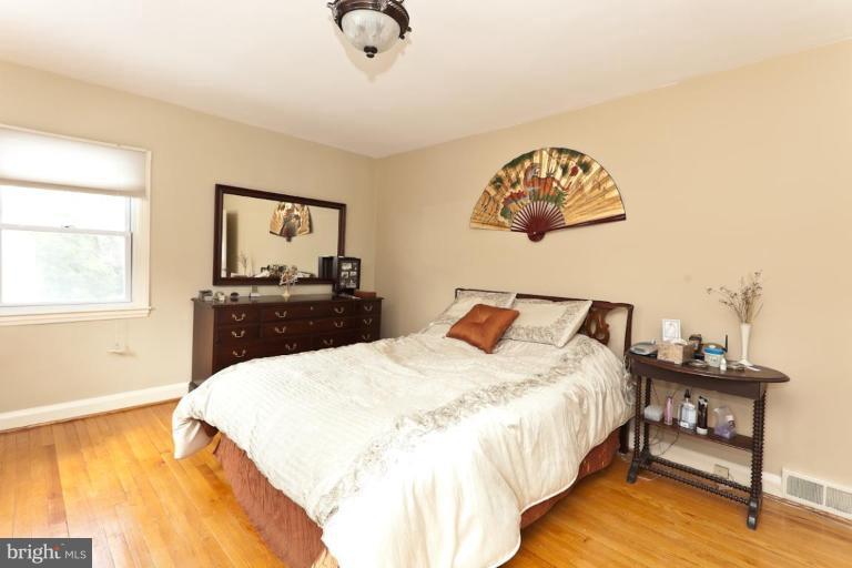 104 Cedarcroft Road Baltimore, MD 21212 - Photo 8 of 21 a bedroom with a bed and a table in it