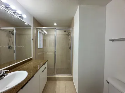 a bathroom with a granite countertop sink a shower and mirror