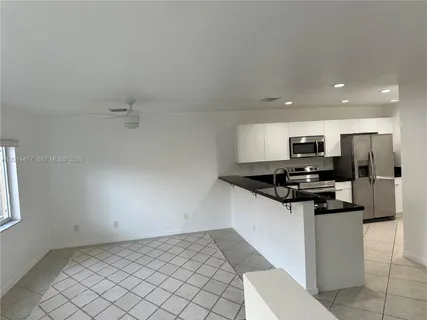 a kitchen with a sink a refrigerator and cabinets