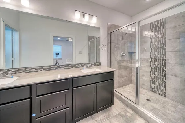 a bathroom with a shower sink and mirror