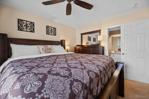 a bedroom with a large bed and a chandelier