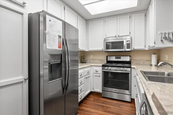 a kitchen with stainless steel appliances granite countertop a refrigerator stove and sink