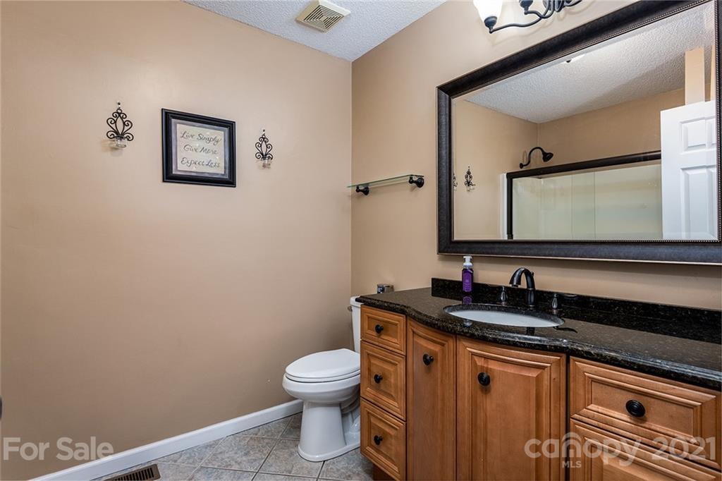 104 Rachel Street Morganton, NC 28655 - Photo 17 of 33 a bathroom with a granite countertop toilet sink and mirror