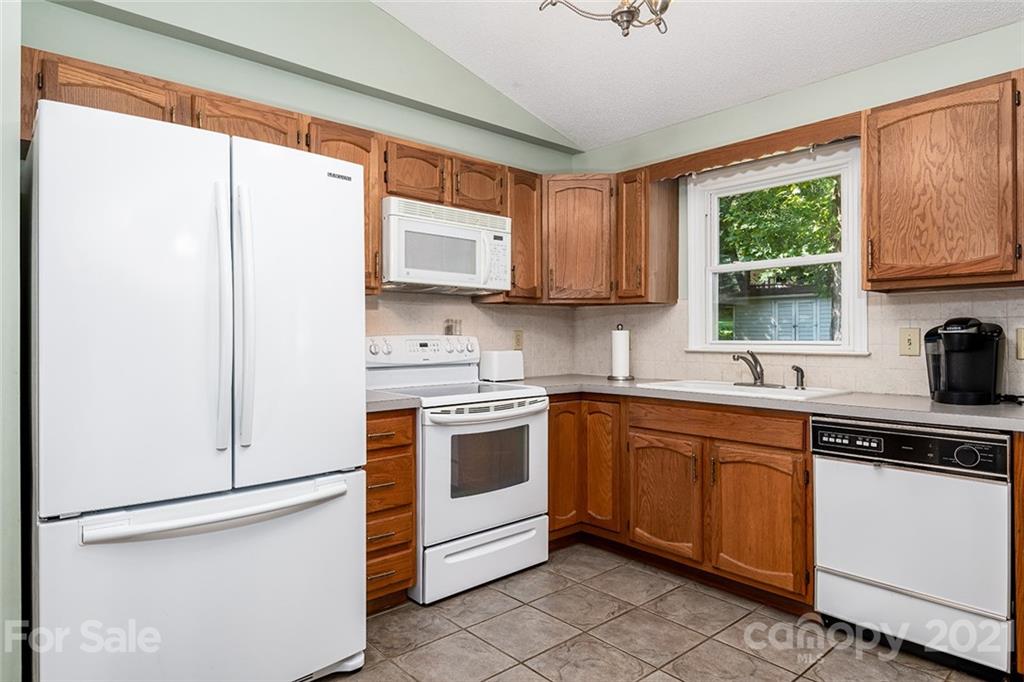 104 Rachel Street Morganton, NC 28655 - Photo 10 of 33 a kitchen with stainless steel appliances granite countertop white cabinets a sink and a window