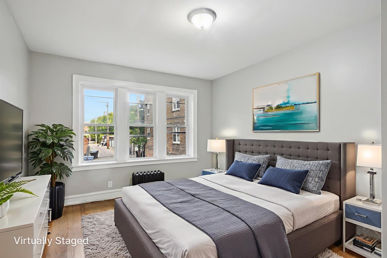 7757 South Phillips Avenue, Unit 3 Chicago, IL 60649 - Photo 10 of 14 a bedroom with a large bed and a window