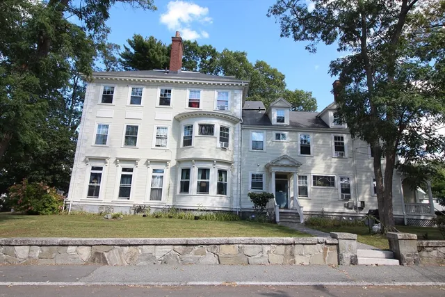 a front view of a residential apartment building with a yard