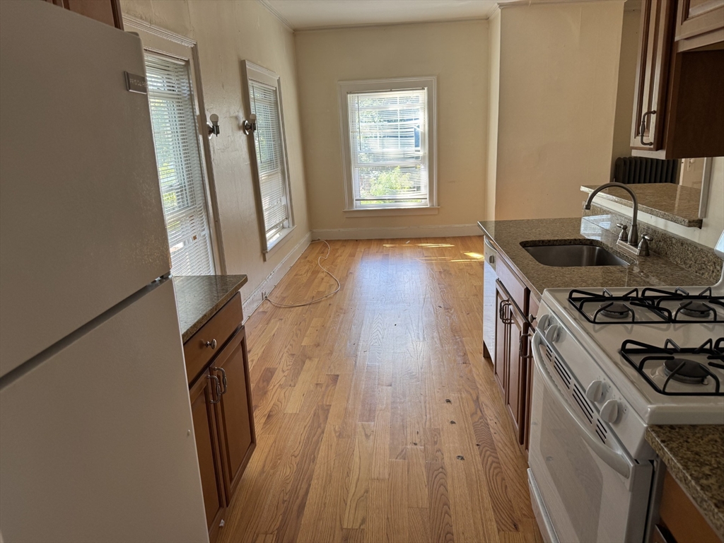 16 Tyler Park, Unit 9 Lowell, MA 01851 - Photo 3 of 10 a kitchen with wooden floors and a stove