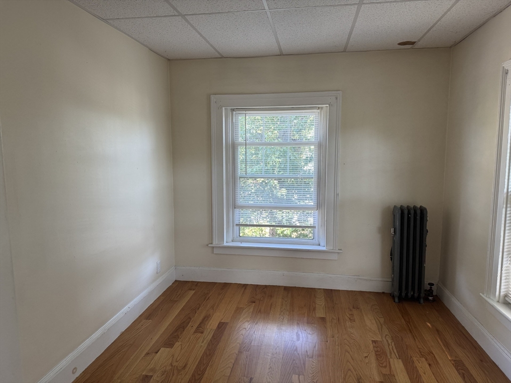 16 Tyler Park, Unit 9 Lowell, MA 01851 - Photo 6 of 10 an empty room with wooden floor and windows