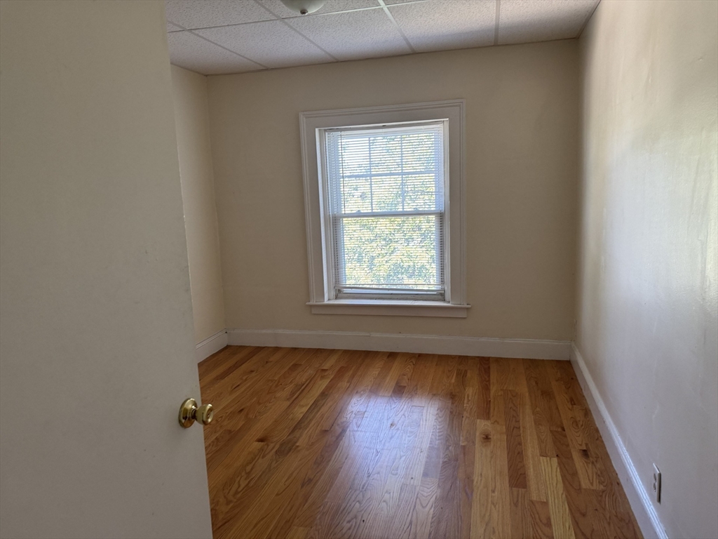 16 Tyler Park, Unit 9 Lowell, MA 01851 - Photo 7 of 10 an empty room with wooden floor and windows