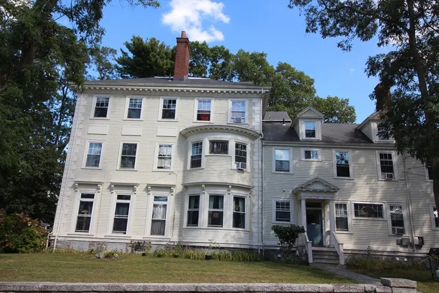 a view of house with yard and large trees